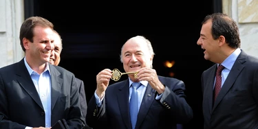 FIFA's President Joseph S. Blatter (C) shows the Rio de Janeiro City key next to Rio de Janeiro's Major Eduardo Paes (L) and Rio de Janeiro's Governor Sergio Cabral at the City Palace in Rio de Janeiro, Brazil, on July 29, 2011. Blatter is in Rio de Janeiro to take part in the Preliminary draw for the FIFA World Cup 2014 which will be held on Saturday. AFP PHOTO/Evaristo SA (Photo credit should read EVARISTO SA/AFP/Getty Images)