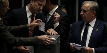 Senadores colocam cédulas de votação no triturador de papel após suspeita de fraude no processo de votação.