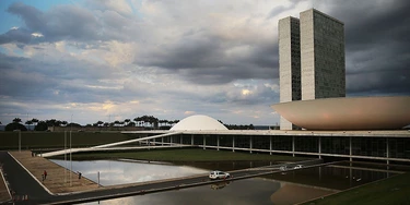 BRASILIA, BRAZIL - OCTOBER 27:  People linger in front of the Brazilian National Congress building on October 27, 2014 in Brasilia, Brazil. Brazil's left-wing President Dilma Rousseff was narrowly re-elected yesterday and will serve another four years in Brazil's unique planned capital city. The modernist city was founded in 1960 and replaced Rio de Janeiro as the federal capital of Brazil. The city was designed by urban planner Lucio Costa and architect Oscar Niemeyer and is now a UNESCO World Hertiage site.  (Photo by Mario Tama/Getty Images)
