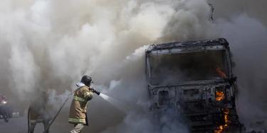 Firefighters work to extinguish a truck allegedly set on fire by drug traffickers in Rio de Janeiro, Brazil, Tuesday, May 2, 2017. Several public buses were torched in Rio de Janeiro on Tuesday in what Brazilian military police said was likely gang retaliation for a large anti-drug operation. (AP Photo/Silvia Izquierdo)