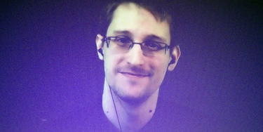Former U.S. National Security Agency contractor Edward Snowden, who is in Moscow, is seen on a giant screen during a live video conference for an interview as part of Amnesty International's annual Write for Rights campaign at the Gaite Lyrique in Paris, France, Dec. 10, 2014. (AP Photo/Charles Platiau, Pool)