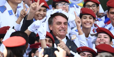 Brazilian congressman and presidential canditate for the next presidential election, Jair Bolsonaro (C), poses for pictures with students of Brasilia's Military School after a parade on the Brazilian Army commemorative day,in Brasilia, on April 19, 2018. (Photo by EVARISTO SA / AFP)        (Photo credit should read EVARISTO SA/AFP/Getty Images)