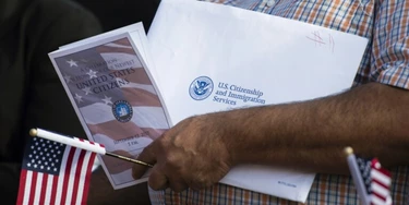 Imigrante segura documentos durante cerimônia de naturalização