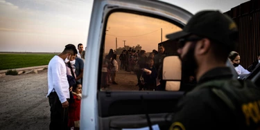 Imigrantes em busca de asilo esperam para serem registrados por agentes da Patrulha de Fronteira depois de cruzar o limite entre México e Estados Unidos em Yuma, Arizona, em 3 de maio de 2022. 