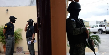 ntegrantes da Direção de Luta contra o Narcotráfico de Honduras (DLCN) e agentes das Forças Armadas participam de operação de apreensão de 32 imóveis, 15 veículos e nove empresas comerciais de seis oficiais de polícia hondurenhos acusados de participar de esquema de tráfico de drogas (Orlando Sierra/AFP/Getty Images)