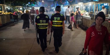 Patrulha policial em um mercado noturno perto da Mesquita de Id Kah na Região Autônoma Uigur de Xinjiang, na China, em 25 de junho de 2017, um dia antes do feriado de Eid al-Fitr.