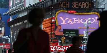NEW YORK - JULY 29:  Pedestrians walk by a Yahoo sign in Times Square on July 29, 2009 in New York City. Taking aim at Google?s dominance, technology companies Microsoft and Yahoo announced Wednesday that they have reached a 10 year internet search partnership.  (Photo by Spencer Platt/Getty Images)