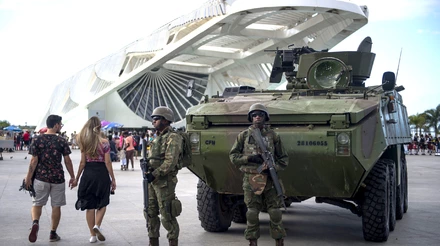 Brazilian marines with armoured personnel carriers (APC) stand guard at the Museum of Tomorrow area in the portuary zone of Rio de Janeiro, Brazil, on July 29, 2017. Brazil has mobilized some 8,500 soldiers to Rio de Janeiro state to fight organized crime and a spike in street violence. President Michel Temer signed a decree allowing the use of the armed forces in Rio de Janeiro state, the official government gazette announced. / AFP PHOTO / Mauro PIMENTEL (Photo credit should read MAURO PIMENTEL/AFP/Getty Images)
