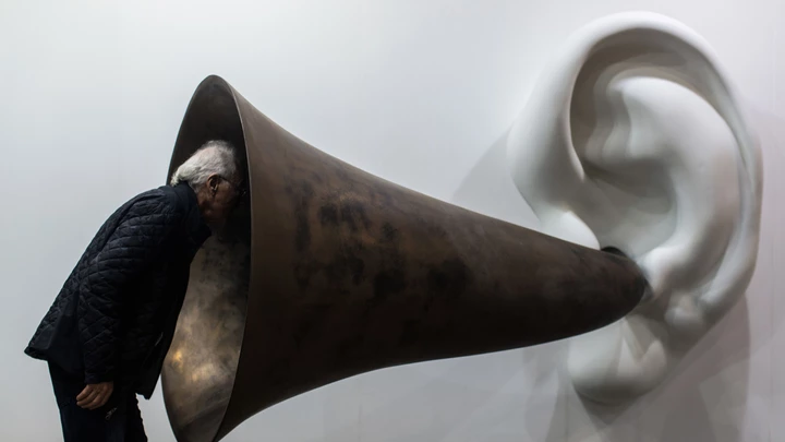 A visitor peers into US artist John Baldessari's "Beethoven's Trumpet (With Ear) Opus # 133" at the Art Basel fair in Hong Kong on March 15, 2015. Hong Kong's biggest art fair, Art Basel, opened its doors with thousands of visitors expected for a city-wide canvas of creativity and commerce. AFP PHOTO / ANTHONY WALLACEMANDATORY MENTION OF THE ARTIST, TO ILLUSTRATE THE EVENT AS SPECIFIED IN THE CAPTION (Photo credit should read ANTHONY WALLACE/AFP/Getty Images)