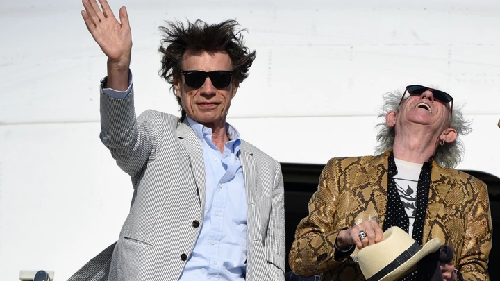 British The Rolling Stones' Mick Jagger waves next to Keith Richards upon arrival in Montevideo on February 15, 2016, on the eve of their presentation within the America Latina Ole Tour.   AFP PHOTO / PABLO PORCIUNCULA / AFP / PABLO PORCIUNCULA        (Photo credit should read PABLO PORCIUNCULA/AFP/Getty Images)