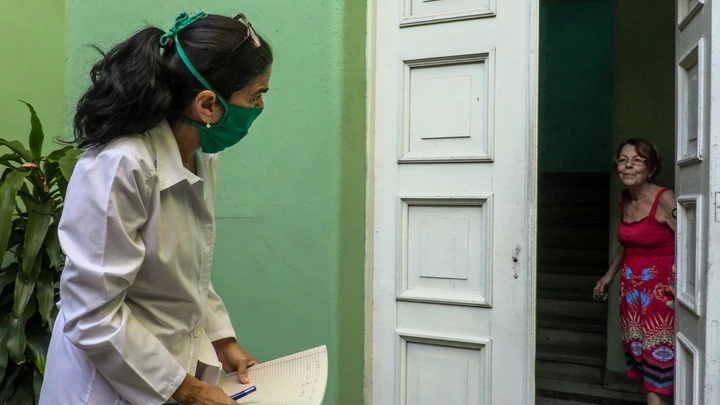 Cuban doctor Liz Caballero (L), interviews a woman as she goes door by door looking for possible cases of the novel coronavirus, COVID-19, in Havana on March 31, 2020. - As Cuba struggles under the weight of US sanctions, COVID-19 has given the country's medical sector the opportunity to export their services in the midst of the coronavirus pandemic. (Photo by Adalberto ROQUE / AFP) (Photo by ADALBERTO ROQUE/AFP via Getty Images)