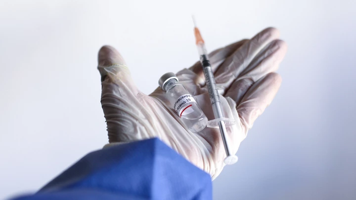 Representative image of a hand holding a vaccine and a vial, in Buenos Aires, Argentina, on December 16, 2020 (Photo illustration by Carol Smiljan/NurPhoto via Getty Images)