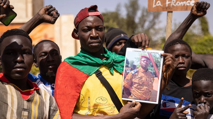 Manifestantes reunidos em Ouagadougou, capital da Burkina Faso, para demonstrar apoio aos militares, seguram uma fotografia do tenente-coronel Paul-Henri Sandaogo Damiba, em 25 de janeiro de 2022.