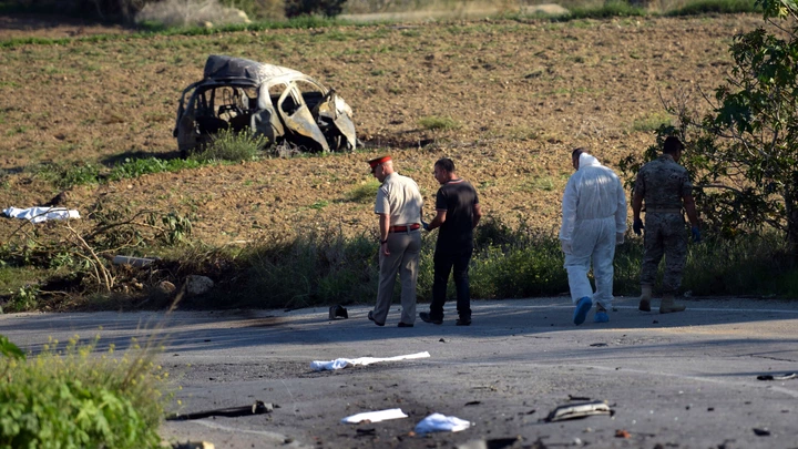 TOPSHOT - Police and forensic experts inspect the wreckage of a car bomb believed to have killed journalist and blogger Daphne Caruana Galizia close to her home in Bidnija, Malta, on October 16, 2017. The force of the blast broke her car into several pieces and catapulted the journalist's body into a nearby field, witnesses said. She leaves a husband and three sons.
Caruana Galizia's death comes four months after Prime Minister Joseph Muscat's Labour Party won a resounding victory in a general election he called early as a result of scandals to which Caruana Galizia's allegations were central.  / AFP PHOTO / STR / Malta OUT        (Photo credit should read STR/AFP/Getty Images)