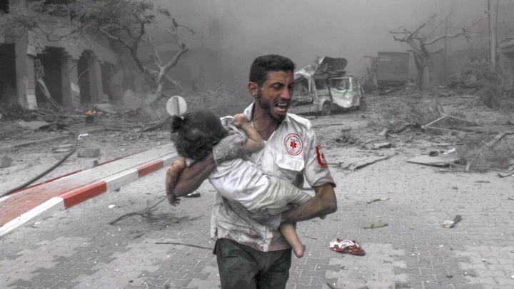 Socorrista leva criança às pressas para ambulância para tratamento depois de ataques aéreos de Israel destruírem edifícios em Gaza, em 9 de outubro de 2023. Foto: Belal Khaled/Agência Anadolu via Getty Images