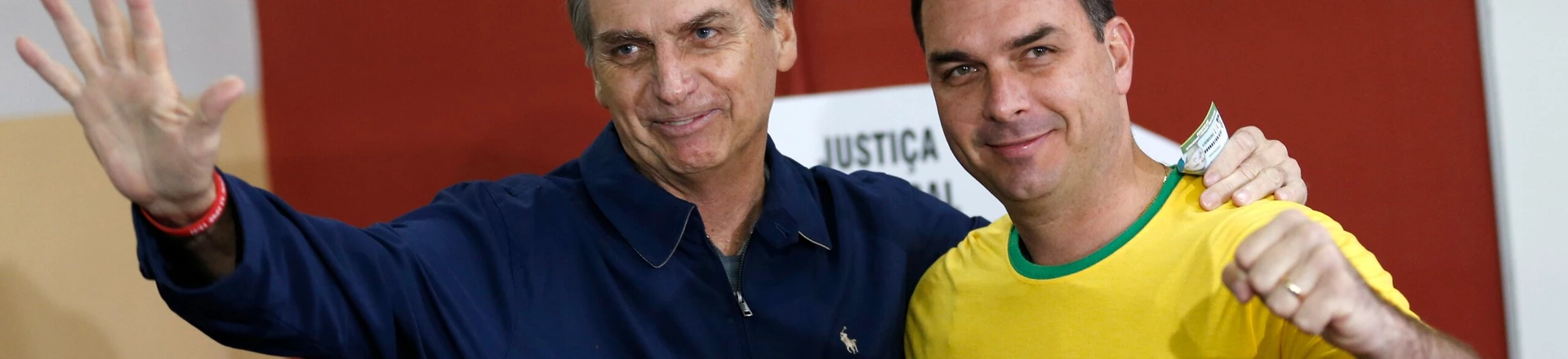FILE - In this Oct. 7, 2018 file photo, then presidential frontrunner Jair Bolsonaro, left, and his son Flavio, acknowledge reporters at a polling station in Rio de Janeiro, Brazil. The son of Brazilian President-elect Jair Bolsonaro is denying wrongdoing in a case involving suspect bank transactions. According to a recent Financial Activities Control Council report, Flavio Bolsonaro's driver deposited various amounts between January 2016 and January 2017. On Thursday, Dec. 13, 2018, Flavio Bolsonaro posted on Twitter that he had “done nothing wrong.” (AP Photo/Silvia Izquierdo, File)