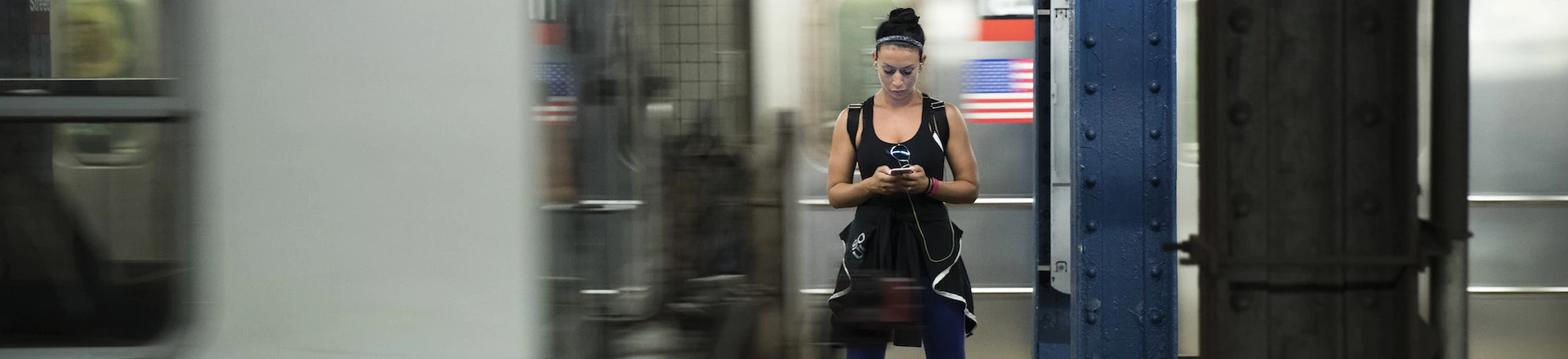 NEW YORK, NY - JULY 20: A woman looks at her smartphone as a train passes by at the 14th Street subway station, July 20, 2016 in New York City. The Metropolitan Transportation Authority (MTA) has placed digital signage in subway stations encouraging riders to be safe while playing the Pokemon Go app on their smartphones. (Photo by Drew Angerer/Getty Images)