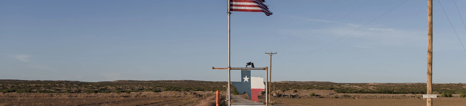 Bandeira em propriedade próxima ao muro que marca a fronteira entre os países Estados Unidos e México.
