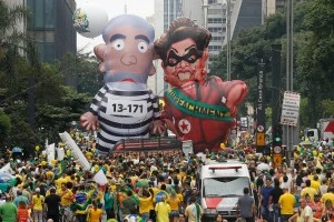 Demonstrators parade large inflatable dolls depicting Brazil's former President Luiz Inacio Lula da Silva in prison garb and current President Dilma Rousseff dressed as a thief, with a presidential sash that reads "Impeachment," in Sao Paulo, Brazil, Sunday, March 13, 2016. The corruption scandal at the state-run oil giant Petrobras has ensnared key figures from Rousseff’s Workers’ Party, including her predecessor and mentor, Lula da Silva, as well as members of opposition parties. (AP Photo/Andre Penner)