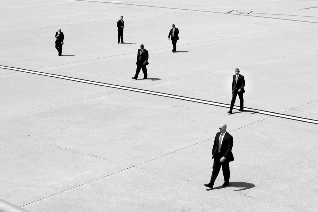 O Presidente Barack Obama caminhando com agentes dos Serviços Secretos dos Estados Unidos para o Air Force One, no Aeroporto Internacional de Los Angeles, Califórnia, 8 de maio de 2014. (Foto oficial da Casa Branca por Pete Souza) </p><br /><br /><br /> <p>Essa foto oficial da Casa Branca é disponibilizada apenas para publicação por organizações noticiosas e/ou uso pessoal pelos sujeitos da fotografia. A fotografia não pode ser manipulada por meio algum e não pode ser usada em materiais comerciais ou políticos, anúncios, emails, produtos ou promoções que de alguma forma possam sugerir a aprovação ou o aval do Presidente, da Primeira Família ou da Casa Branca.