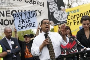 Rep. Keith Ellison, D-Minn. joins low-wage workers at a rally outside the Capitol in Washington, Monday, April 28, 2014, to urge Congress to raise the minimum wage as lawmakers return to Washington following a two week hiatus. Democratas vêm pressionando pelo aumento do salário mínimo, mas mesmo se a lei for aprovada no Senado, é certo que será ignorada pelo Congresso, controlado por republicanos.  (AP Photo)