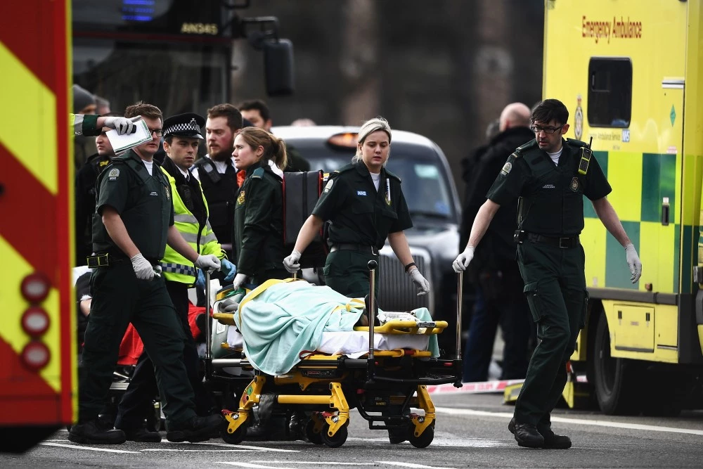 LONDON, ENGLAND - MARCH 22:  A member of the public is treated by emergency services near Westminster Bridge and the Houses of Parliament on March 22, 2017 in London, England. A police officer has been stabbed near to the British Parliament and the alleged assailant shot by armed police. Scotland Yard report they have been called to an incident on Westminster Bridge where several people have been injured by a car.  (Photo by Carl Court/Getty Images)