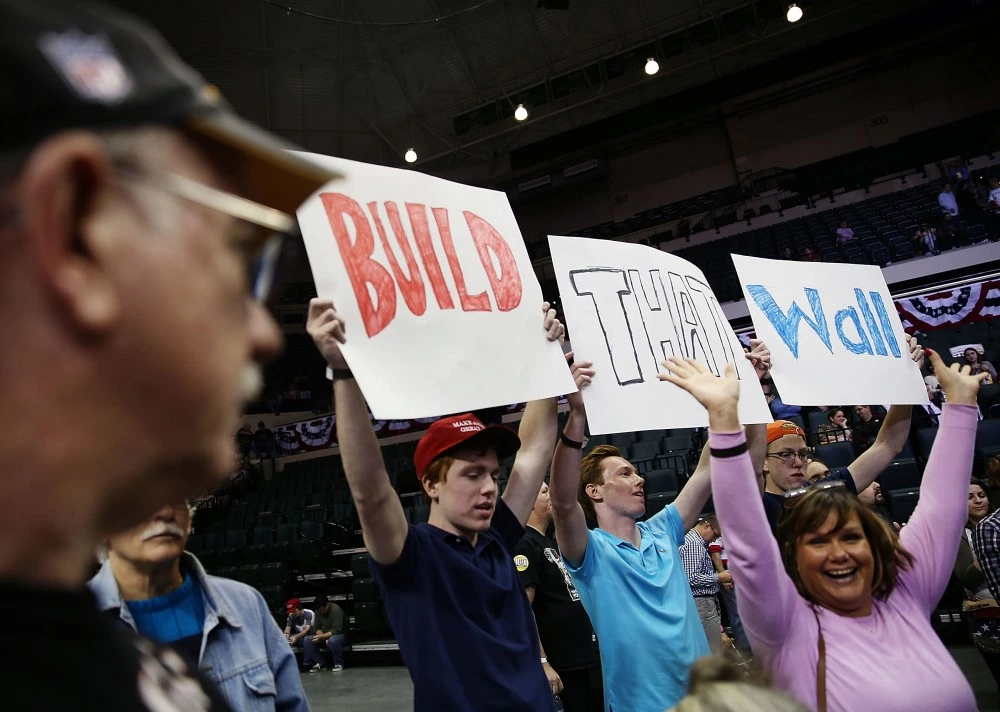 TAMPA, FL - FEBRUARY 12: People hold signs that read, " Build that Wall", as they wait for the start of a campaign rally for Republican presidential candidate Donald Trump at the University of South Florida Sun Dome on February 12, 2016 in Tampa, Florida. The process to select the next Democratic and Republican Presidential candidate continues.  (Photo by Joe Raedle/Getty Images)