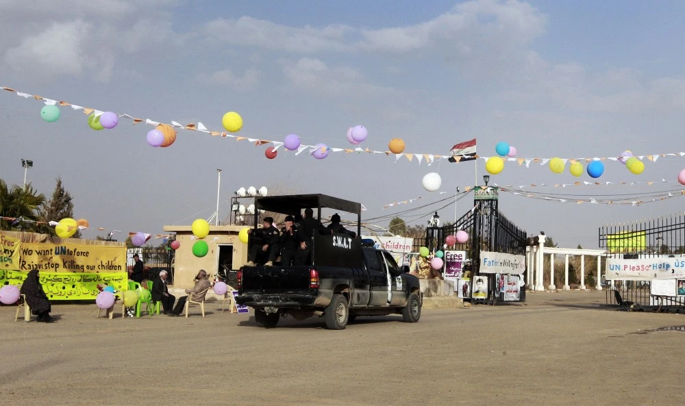 FILE - In this file photograph taken on Friday, Feb. 17, 2012, Iraqi security forces enter through the main gate of Camp Ashraf in Khalis, north of Baghdad, Iraq. The Mujahedeen-e-Khalq, an Iranian dissident group, is accusing Iraqi authorities of cutting off water and electricity to a contested northern camp for Iranian exiles, a charge the Iraqi government denies. Baghdad wants to shut Camp Ashraf and move remaining residents to a Baghdad-area camp before relocating them abroad. (AP Photo/Hadi Mizban, File)