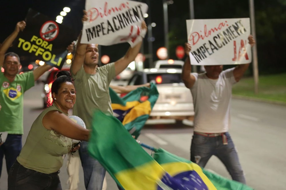 FILE - In this Dec. 2, 2015 file photo, people demonstrate against the government as they take part in protest in favor of impeaching Brazil's President Dilma Rousseff, in front of the National Congress, in Brasilia, Brazil. The country has seen a vicious circle of ballooning crises over the past year. Major scandals, some of which are connected to Rousseff, have combined with tanking commodity prices to deliver blows to the powerhouse economy, including credit-rating downgrades, a sharp currency devaluation and 10-percent annual inflation. (AP Photo/Eraldo Peres, File)