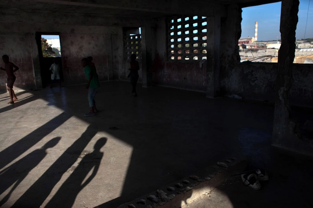 PORT-AU-PRINCE, HAITI - JANUARY 27:  Boys play in the ruins of a building on the site of the Fort Dimanche prison, where many were held in inhumane conditions under the regime of Jean-Claude "Baby Doc" Duvalier January 27, 2011 in Port-au-Prince, Haiti.  The area is now a residential neighborhood called "Democracy Village". Duvalier returned from exile earlier this month and was questioned by authorities before being released. His critics accuse him of stealing from the treasury during his rule and for crimes against humanity.  (Photo by Allison Shelley/Getty Images)