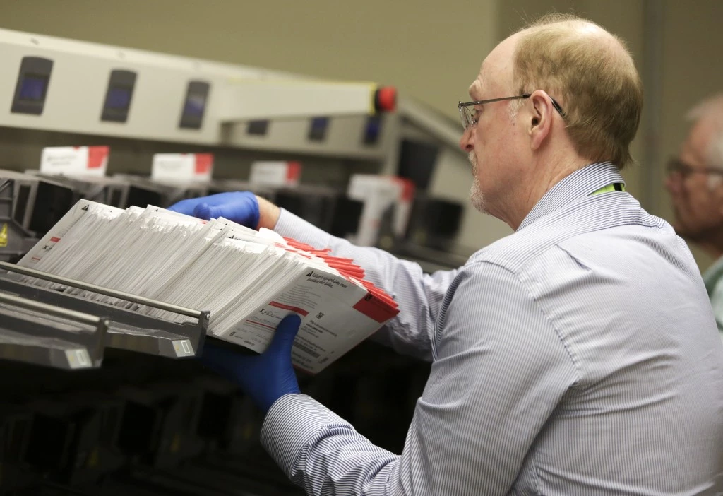 Temporary elections workers use a machine to scan signatures and sort mail-in ballots at the King County County Department of Elections in Renton, Washington on November 2, 2016.Washington, Oregon and Colorado are three states that conduct all elections by mail and there are no traditional polling places. / AFP / Jason Redmond (Photo credit should read JASON REDMOND/AFP via Getty Images)