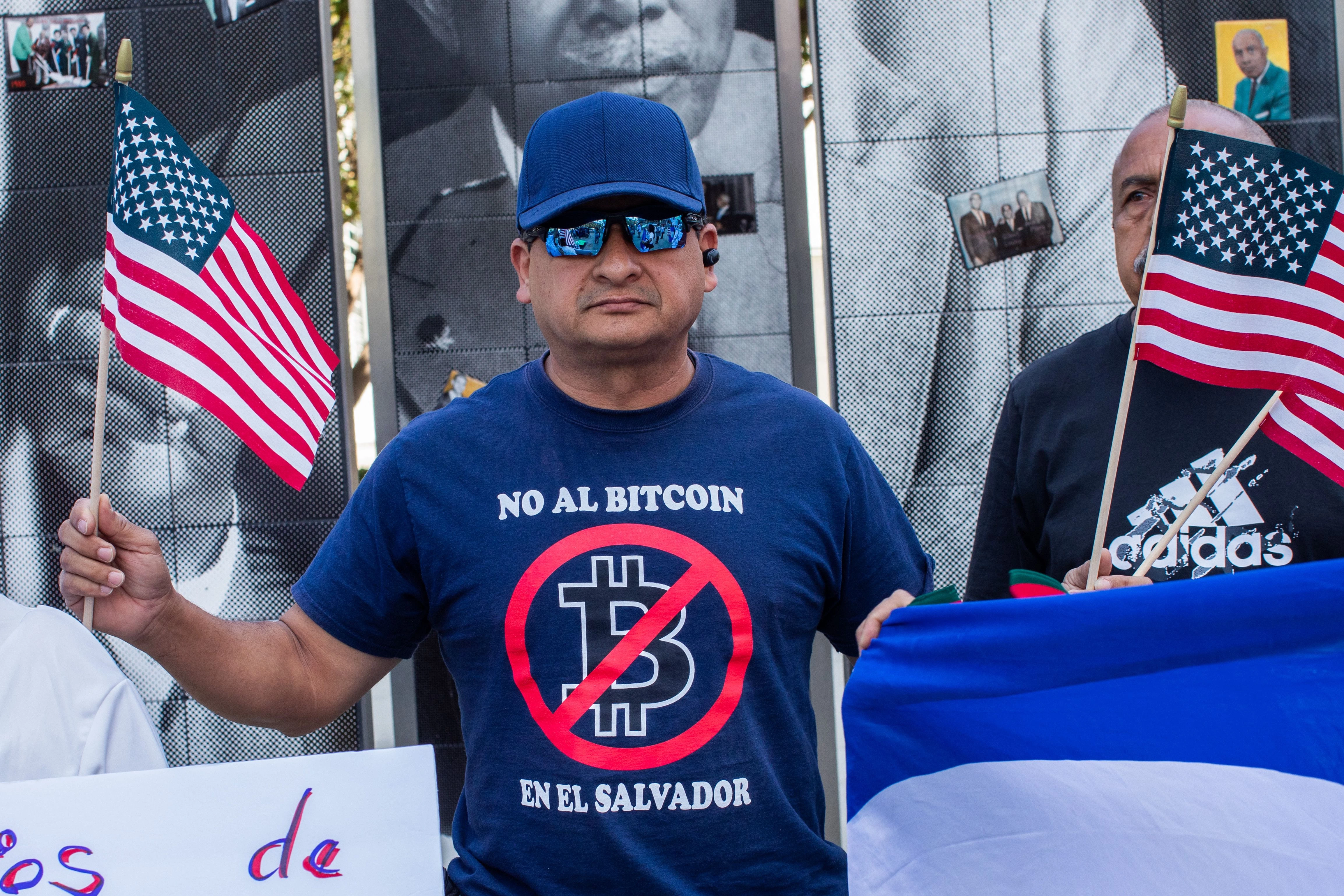 Osmar Zelaya holds American flags in front of the LA Convention Center to protest against the President of El Salvador Nayib Bukele, in Los Angeles, California, on June 06, 2022. - Leaders from North and South America will gather in Los Angeles from June 6 through June 10 to meet for the ninth Summit of the Americas. (Photo by Apu GOMES / AFP) (Photo by APU GOMES/AFP via Getty Images)