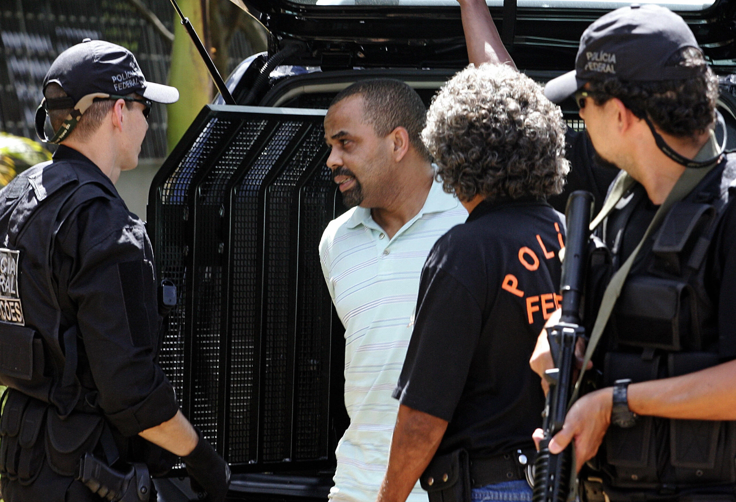 Brasilia, BRAZIL:  Brazilian drug trafficker Luiz Fernando da Costa (2-L) a.k.a. Fernandinho Beira-Mar is seen next to federal police officers upon his arrival from Maceio (NE Brazil) at Police headquarters in Brasilia, 24 March 2006.  AFP PHOTO/Evaristo SA  (Photo credit should read EVARISTO SA/AFP/Getty Images)