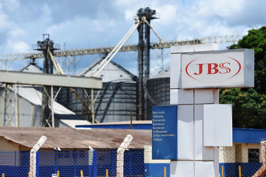 View of the JBS-Friboi Logo at the chicken processing plant entrance, in Samambaia, Federal District, Brazil on March 17, 2017.<br /> Brazilian Federal police have dismantled, after two years of running the "weak flesh" operation, a vast network of adulterated food, involving major meat processing plants and inspectors who accepted bribes to approve products in bad condition for domestic consumption and exportation.  / AFP PHOTO / EVARISTO SA        (Photo credit should read EVARISTO SA/AFP/Getty Images)