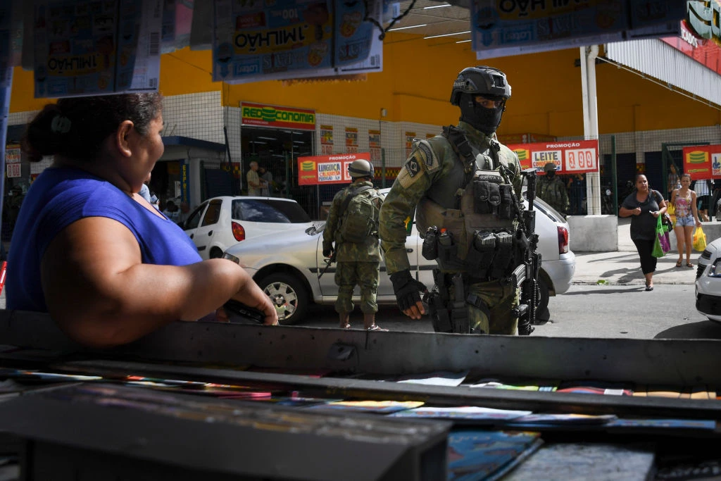 Soldiers take part in a crackdown on crime gangs, at the Lins de Vasconcelos slum complex in Rio de Janeiro, Brazil, on August 5, 2017.Thousands of Brazilian army troops raided Rio de Janeiro slums leaving parts of the city looking like a war zone. Their main goal was to stop gangs behind a surge in brazen robberies of commercial trucks, with arrest warrants issued for 40 people. However, the unusually aggressive pre-dawn operation also follows wider concerns that nearly bankrupt post-Olympic Rio is spinning out of control. / AFP PHOTO / Apu Gomes (Photo credit should read APU GOMES/AFP/Getty Images)