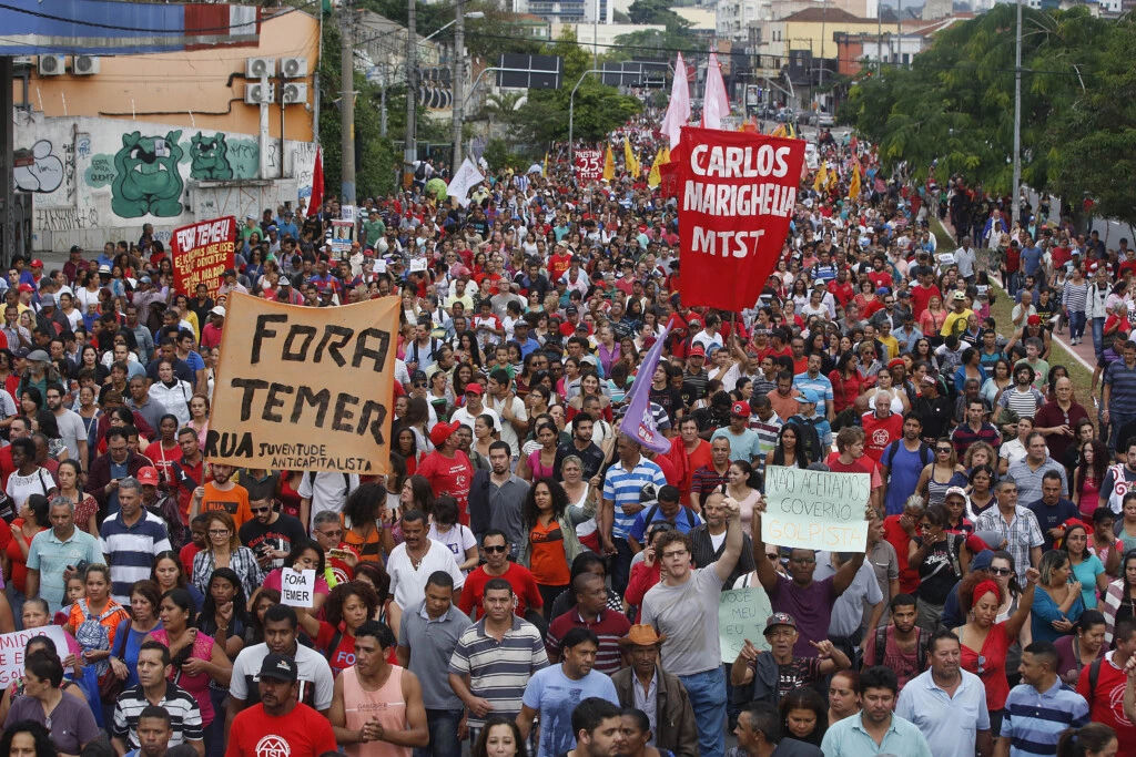 With a sign that reads in Portuguese "Temer out," demonstrators march against Brazil's acting President Michel Temer and in support of Brazil's suspended President Dilma Rousseff, in Sao Paulo, Brazil, Sunday, May 22, 2016. Temer took office after Rousseff was suspended for up to 180 days while the Senate holds an impeachment trial. (AP Photo/Andre Penner)