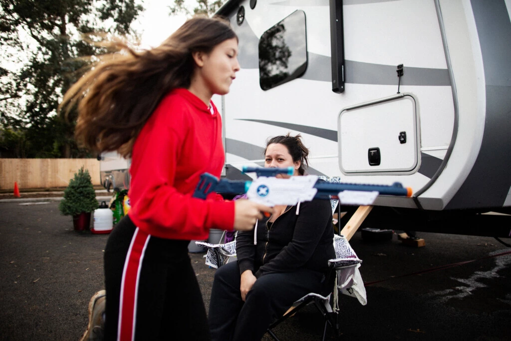 Michelle e a filha de 14 anos na frente do trailer de 28 metros quadrados em que a família está morando desde que perdeu a casa no incêndio de Camp.