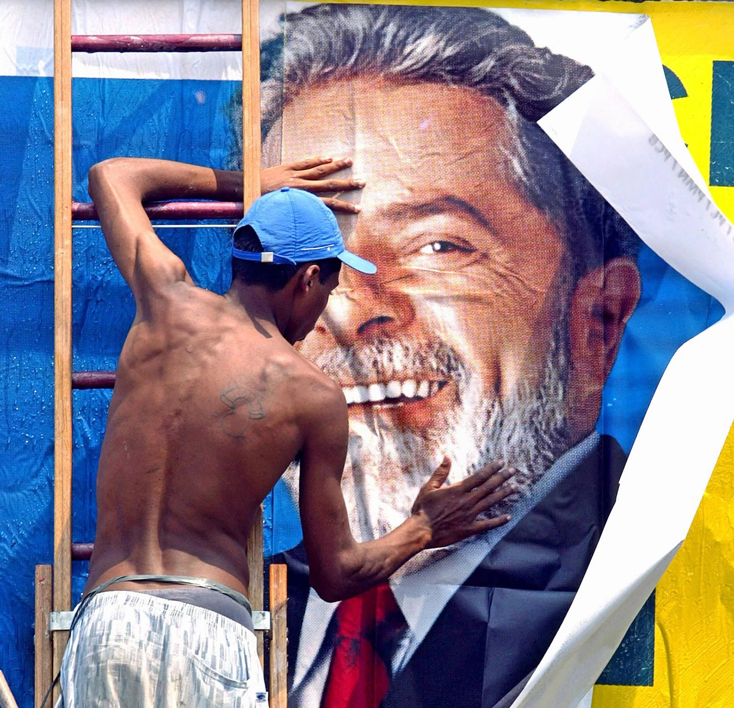 SAO PAULO, BRAZIL:  A worker puts up a campaign sign for Brazilian presidential candidate Luiz Inacio Lula da Silva, of theWorkers Party, (PT) 24 October, 2002, in Sao Paulo, Brazil. Lula heads to the 27 October second round of voting with 65 percent support and a massive lead over the ruling party's Jose Serra. AFP PHOTO/Mauricio LIMA   Un trabajador pega un afiche con la imagen de Luiz Inacio Lula da Silva, candidato opositor del Partido de los Trabajadores (PT) a la presidencia de Brasil, el 24 de octubre de 2002, en Sao Paulo, Brasil. Segun sondeos Lula, obtendria del 66% de las intenciones de voto para el balotaje del 27 de octubre, mientras que Jose Serra, del Partido de la Social Democracia Brasilena (PSDB), obtendria el 34%.  AFP PHOTO/Mauricio LIMA (Photo credit should read MAURICIO LIMA/AFP/Getty Images)