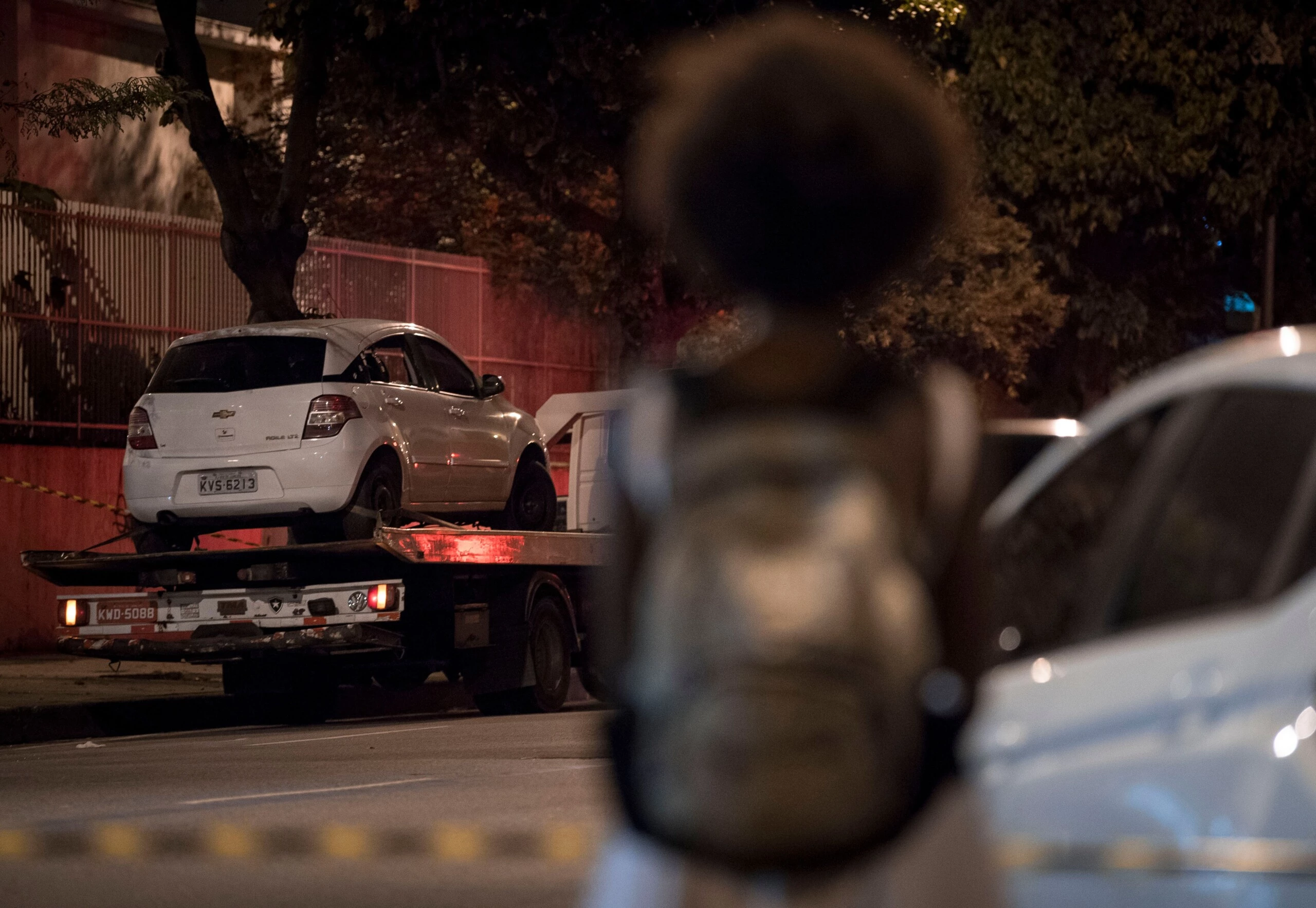 People look on as Rio's Civil Police transport Brazilian politician Marielle Franco's car, where she was found shot dead in Rio de Janeiro, Brazil on March 15, 2018.  Marielle was elected as Rio's councilwoman through Brazilian left-wing party PSOL. Marielle Franco was killed when she was returning from an event in Lapa neighborhood, downtown Rio de Janeiro. Her driver died too.  / AFP PHOTO / Mauro Pimentel        (Photo credit should read MAURO PIMENTEL/AFP via Getty Images)