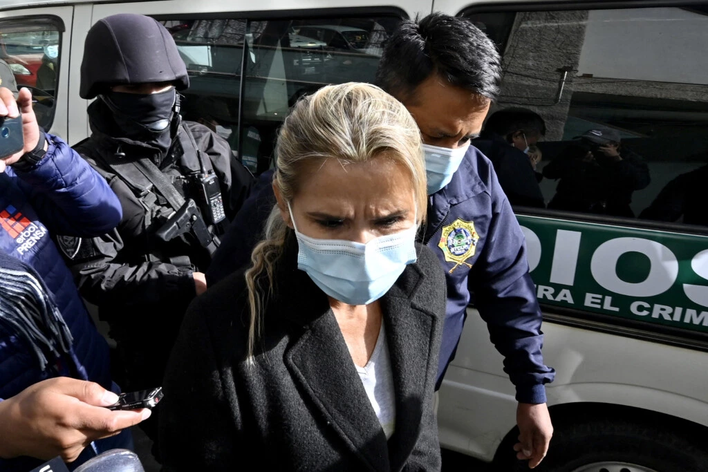 Former interim Bolivia's President Jeanine Anez (C) is escorted by police members of the Special Force against Crime (FELCC) after being arrested in La Paz, on March 13, 2021. - Bolivia's former interim president Jeanine Anez was arrested Saturday on terrorism and sedition charges over what the government claims was a coup attempt against her predecessor and political rival Evo Morales. (Photo by AIZAR RALDES / AFP) (Photo by AIZAR RALDES/AFP via Getty Images)