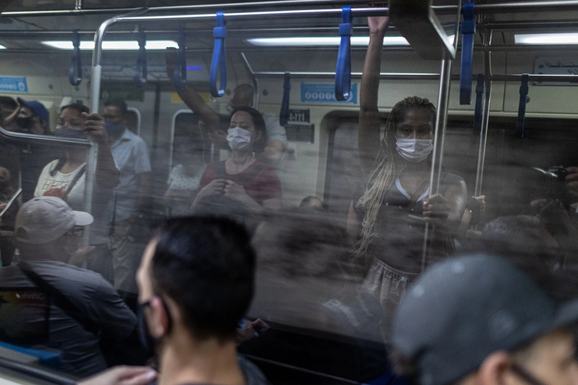 No metro a caminho de sua casa, no Jardim Peri, após um dia de trabalho.Jéssica Alves Maia do Rio Branco, 24 anos. Presta serviço de faxineira desde os 16 anos para aplicativos, empresas e clientes particulares, em jornadas que podem chegar até 12h de trabalho. Em sua casa, no Jardim Peri, na Zona Norte de São Paulo, é responsável pelos cuidados de sua mãe, que é paraplégica, e de sua avó. Para se deslocar de sua residência aos locais de trabalho leva até 3h de transporte público, entre ônibus, metrôs e trens. Seu sonho é ser médica e atualmente está tentando uma vaga para escola militar.