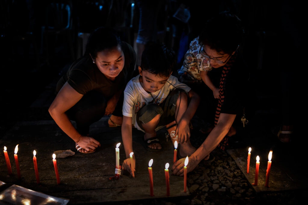 Familiares de vítimas de execuções extrajudiciais acendem velas diante das fotografias de seus entes queridos durante uma vigília na cidade de Quezon, na Região Metropolitana de Manila, nas Filipinas, em 1º de dezembro de 2017.