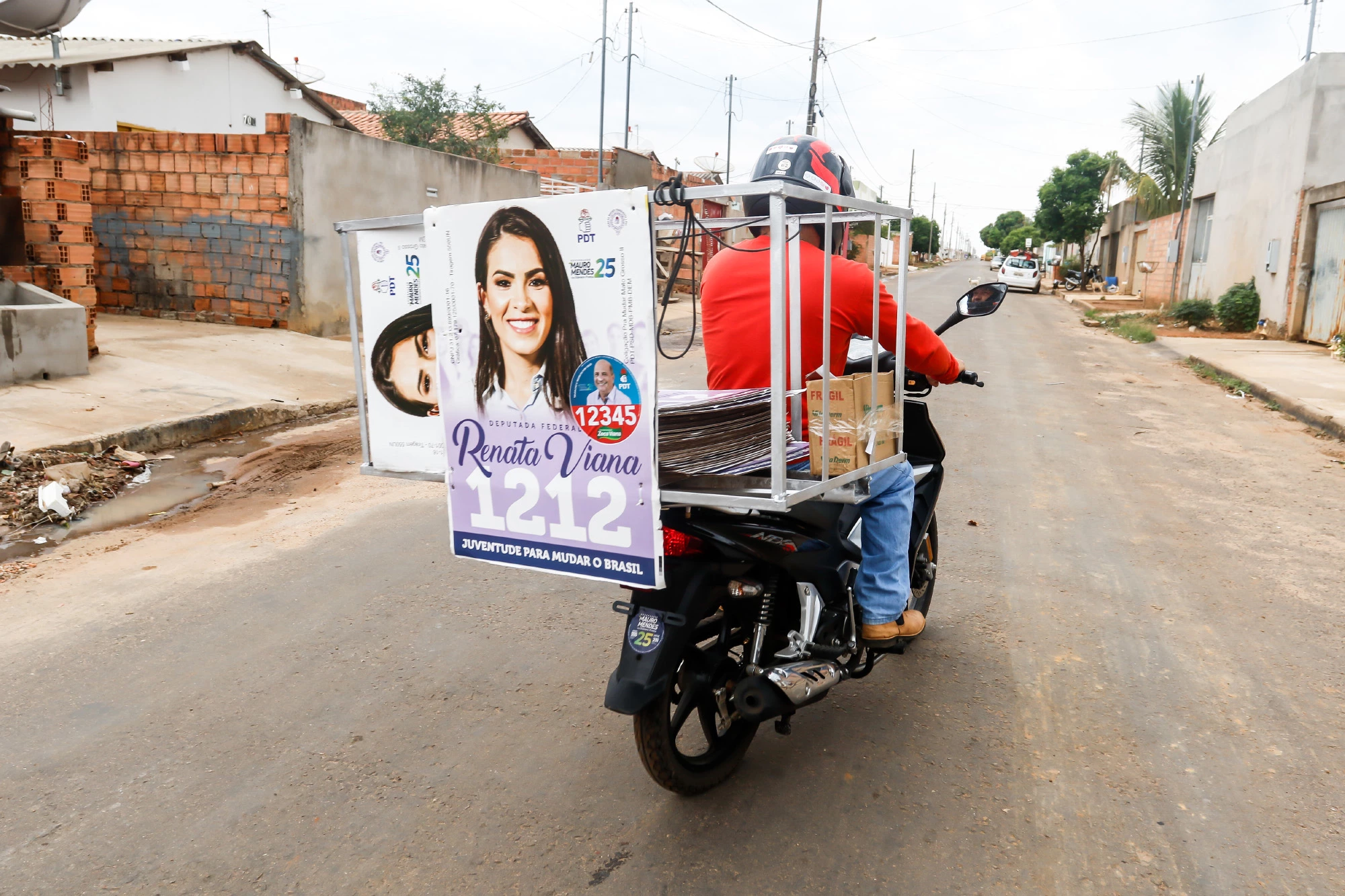 Cabo eleitoral espalha cartazes de campanha de Renata Viana, sobrinha do candidato Zeca Viana (PDT-MT), em bairro pobre de Primavera do Leste.