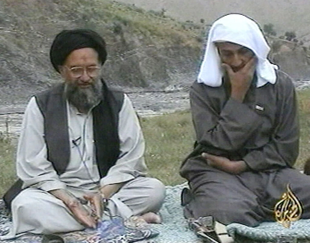 Nessa imagem de televisão da emissora árabe Al Jazeera, Osama Bin Laden, à direita, ouve enquanto um de seus principais delegados, Ayman al-Zawahiri, fala, de local desconhecido, em uma transmissão gravada não datada, em 15 de abril de 2002.