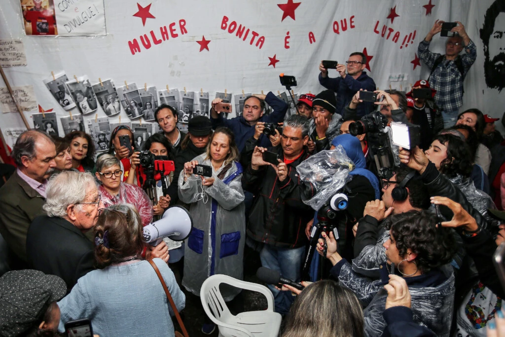 Linguista americano e ativista político, Noam Chomsky (à esquerda) fala com militantes do PT depois de visitar o presidente Luiz Inácio Lula da Silva na prisão no dia 20 setembro.