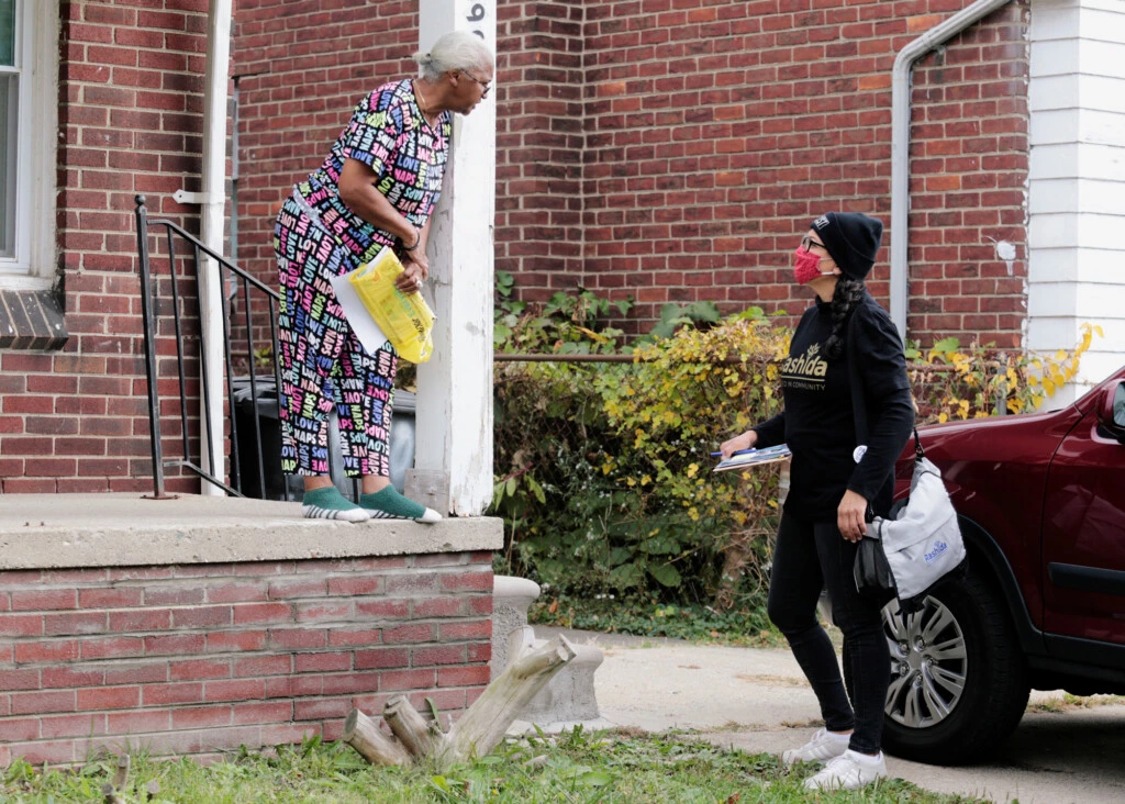 A deputada democrata Rashida Tlaib encoraja um eleitor a votar em Detroit, em 18 de outubro de 2020.