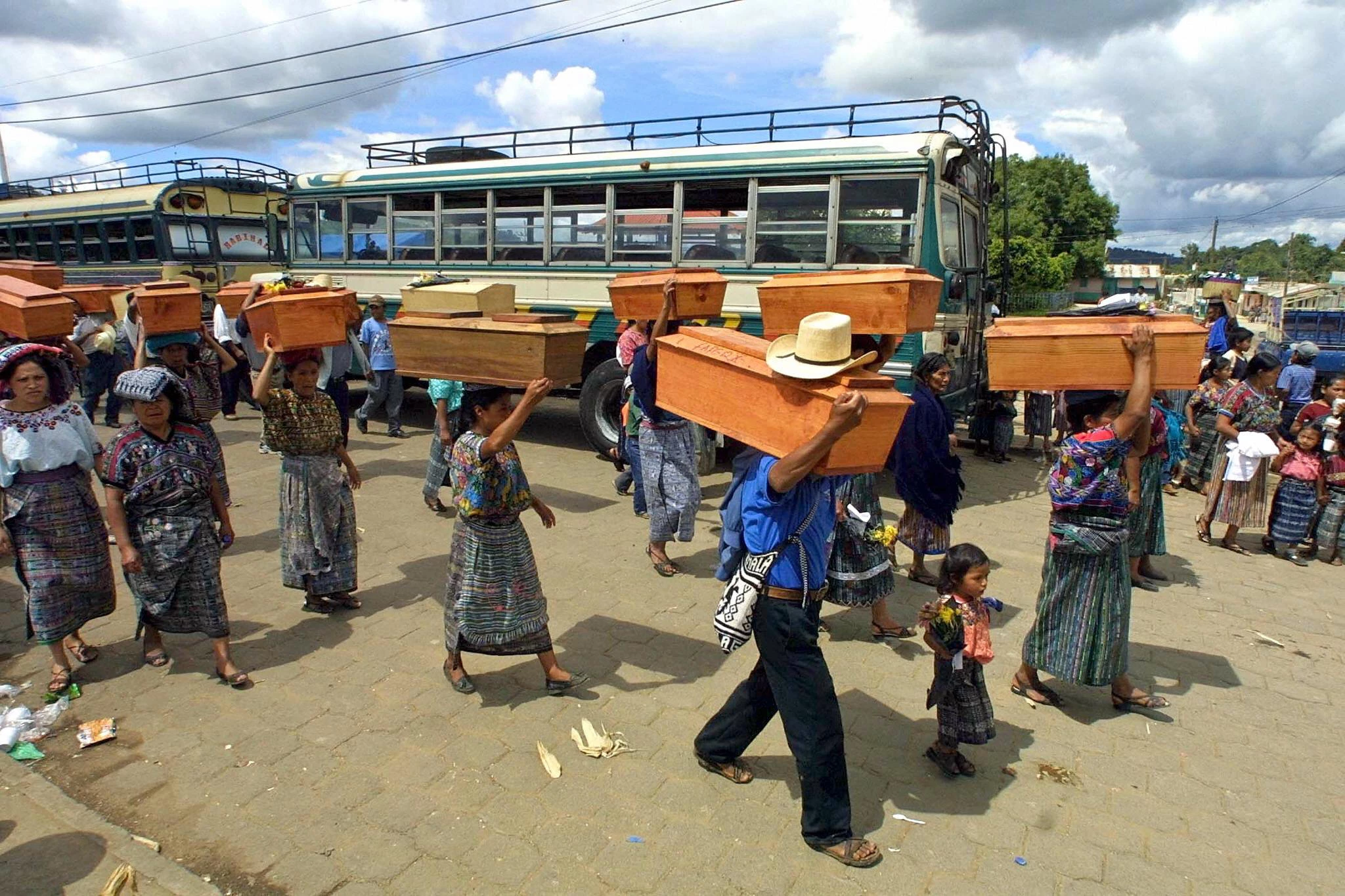 Family members and friends carry their loved ones in coffins, victims of repression, tortures and executions supposedly by the Guatemalan Army and Paramilitary forces during the 80's, at a local cemetery in San Jose Poaquil, Chimaltenango in Guatemala, 12 July 2003. AFP PHOTO/Orlando SIERRA  (Photo credit should read ORLANDO SIERRA/AFP/Getty Images)