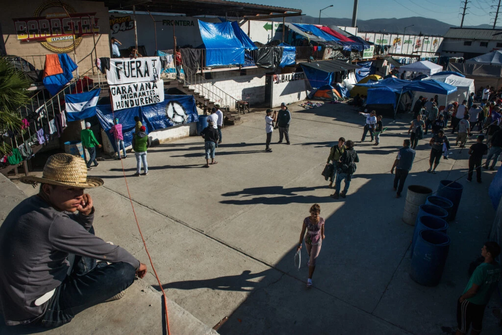 Homem descansa em uma parte elevada do acampamento Barretal em Tijuana, na fronteira entre os EUA e o México, em 8 de dezembro de 2018.