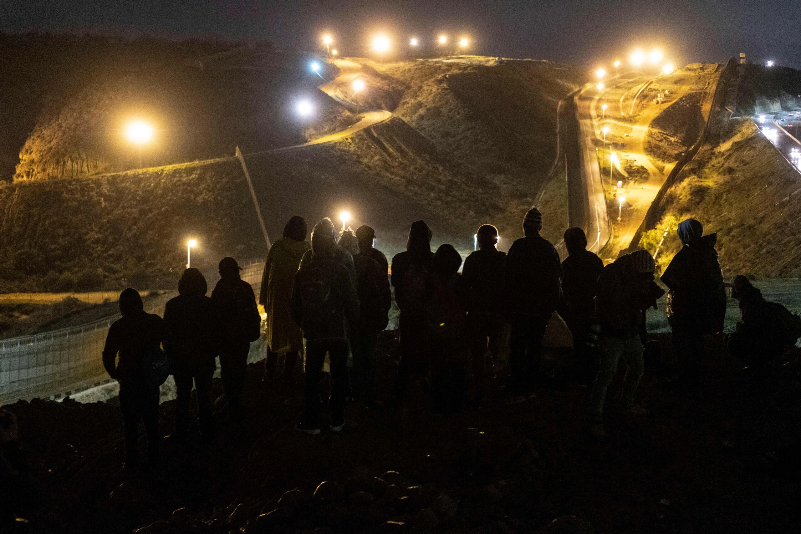 Imigrantes da América Central aguardam sobre um morro antes de tentar atravessar de Tijuana para San Diego em 31 de dezembro de 2018.