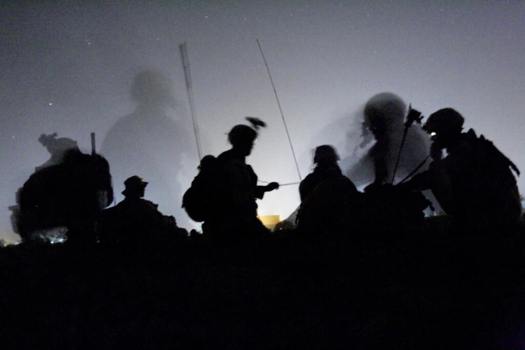 Soldados do Exército dos EUA fazem contato por rádio depois de chegar de helicóptero, à noite, a uma localização secreta no sul de Bagdá, onde acreditavam estar escondido um dos principais líderes da insurgência, membro próximo de Abu Musab al-Zarqawi, em 5 de junho de 2005.
